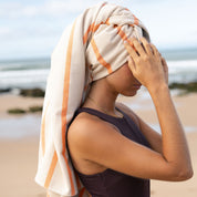 Woman with a towel wrapped around her head on a beach